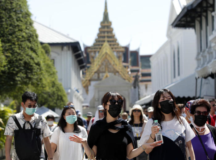 Chinesische Touristen besichtigen mit Mundschutz den Großen Palast in Bangkok. Foto: epa/Rungroj Yongrit