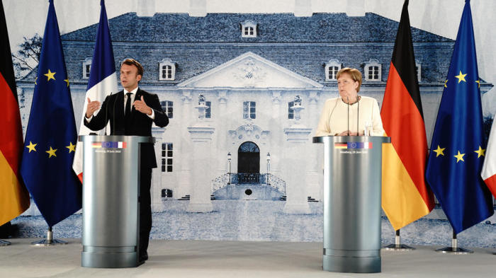 Bundeskanzlerin Angela Merkel (R) und der französische Präsident Emmanuel Macron sprechen auf einer Pressekonferenz. Foto: epa/Kay Nietfeld