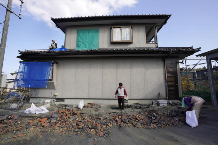 Anwohner sammeln beschädigte Dachziegel nach einem starken Erdbeben der Stärke 7,3 in Soma, Fukushima. Foto: epa/Kimimasa Mayama