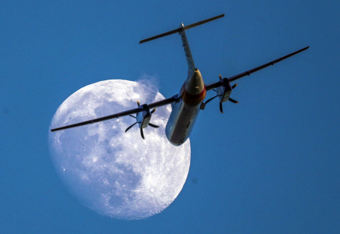 Ein Flugzeug fliegt in den Morgenstunden am Mond beim Abflug vom Flughafen Heathrow. Foto: Steve Parsons/Pa Wire/dpa