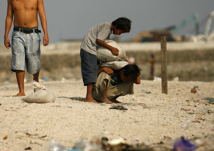 Philippinische Kinder arbeiten, indem sie Sand an einer Uferlinie in den Vororten von Manila auf den Philippinen entfernen. Foto: epa/Francis R. Malasig