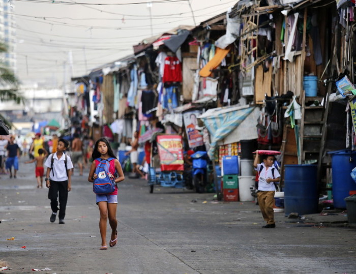 Philippinische Kinder laufen an Baracken in einem Elendsviertel in Manila vorbei Foto: epa/Francis R. Malasig