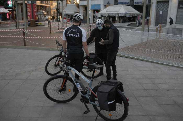 Städtische Polizeibeamte kontrollieren die Dokumente und Genehmigungen von Fußgängern für die Bewegung im Freien während der zweiten Abriegelung des Landes. Foto: epa/Kostas Tsironis