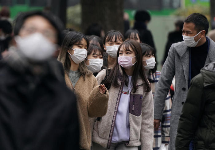 Schutzmasken tragende Fußgänger gehen über einen Zebrastreifen in Tokio. Foto: epa/Kimimasa Mayama