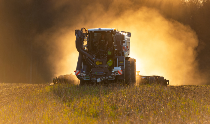 Ein Landwirtschaftlicher Lohnunternehmer fährt mit einem speziellen Fahrzeug Gülle von einer Biogasanlage aus. Dabei wird die Gülle gleich in den Boden eingearbeitet. Foto: Philipp Schulze/Dpa
