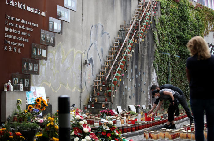 Vermummte Menschen stellen Kerzen an der Gedenkstätte für die Opfer der Loveparade-Katastrophe 2010 in Duisburg auf. Archivfoto: epa/FRIEDEMANN VOGEL