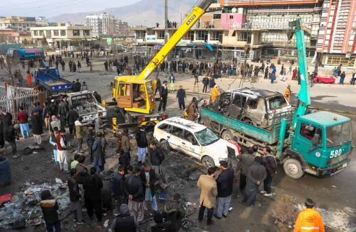Kabuler Polizeibeamte entfernen die Wrackteile eines beschädigten Autos vom Schauplatz einer Bombenexplosion in Kabul. Foto: epa/Hedayatullah Amid