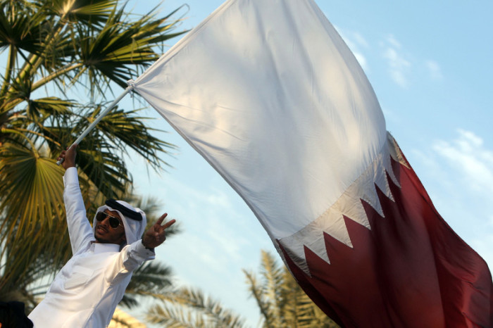  Ein Einwohner des Emirats Katar mit der Nationalflagge. Foto: epa/Mohamed Faraga