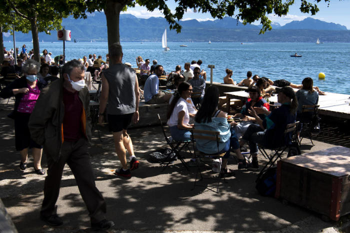 Menschen auf der Außenterrasse eines Restaurants in Lausanne mit Blick auf den Genfer See. Foto: epa/Laurent Gillieron