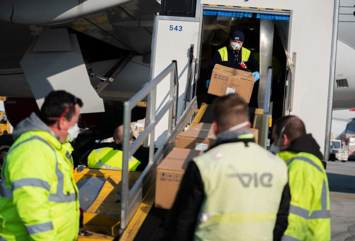 Am Flughafen Wien-Schwechat (VIC) entladen Arbeiter Kisten mit medizinischer Schutzausrüstung aus einem Flugzeug des Typs Boeing 777-200ER. Foto: epa/Georg Hochmuth