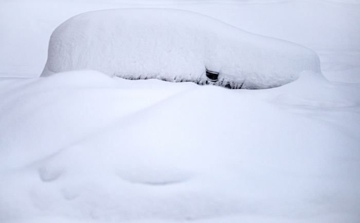St. Moritz: Ein Auto ist nach starkem Schneefall vollständig von Schnee bedeckt. Foto: Jean-Christophe Bott/Keystone/dpa