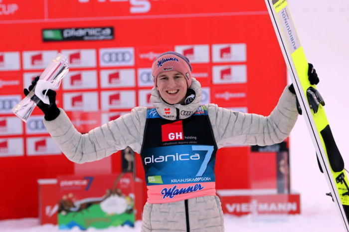 Der deutsche Sieger Karl Geiger feiert auf dem Podium des Einzelwettbewerbs von der Großschanze beim FIS Skisprung-Weltcup in Planica. Foto: epa/Grzegorz Momot