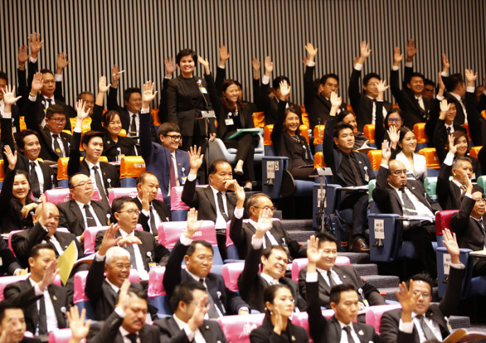 Mitglieder des Repräsentantenhauses erheben ihre Hände, um den Vorsitzenden der Future Forward Party, Thanathorn Juangroongruangkit (nicht auf dem Foto) zu unterstützen. Foto: epa/Narong Sangnak