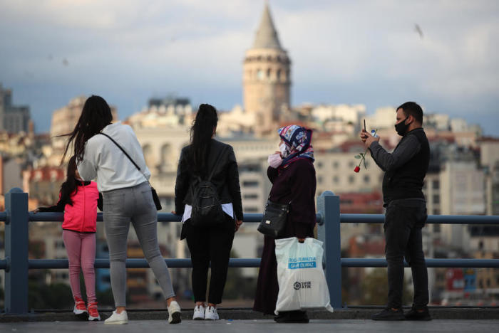 Leute fotografieren an der Galata-Brücke in der Nähe des Bosporus an einem sonnigen Tag inmitten der anhaltenden Coronavirus-Pandemie in Istanbul. Foto: epa/Tolga Bozoglu