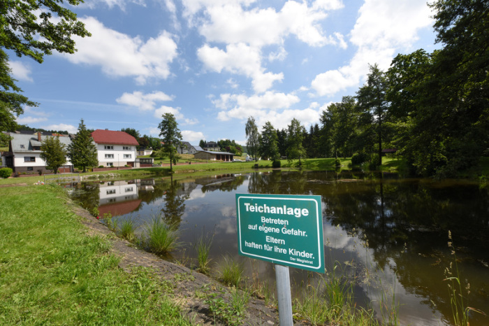 Ein Schild mit der Aufschrift «Teichanlage - Betreten auf eigene Gefahr. Eltern haften für ihre Kinder.» steht an einem Teich im Ortsteil Seigertshausen. Foto: Frank Rumpenhorst/Dpa