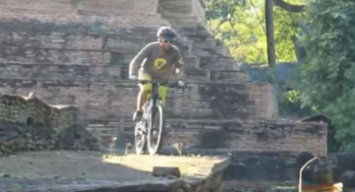 Ausländer fährt mit Mountainbike auf Tempelgelände