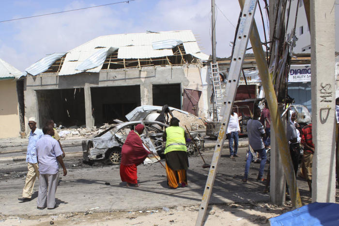Menschen säubern den Schauplatz einer Selbstmord-Autobombenexplosion an einem Kontrollpunkt in der Nähe des Parlaments in Mogadischu.Foto: epa/Said Yusuf Warsame