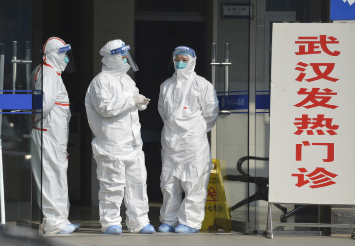 28. Januar 2020: Medizinisches Personal in Schutzanzügen am Eingang einer Klinik in Wuhan für Patienten, die sich mit dem Corona-Virus infiziert haben. Foto: CHINATOPIX/Ap/dpa