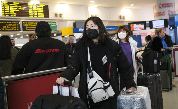 Personen mit medizinischen Masken kommen auf dem internationalen Flughafen John F. Kennedy in New York an. Foto: epa/Justin Lane