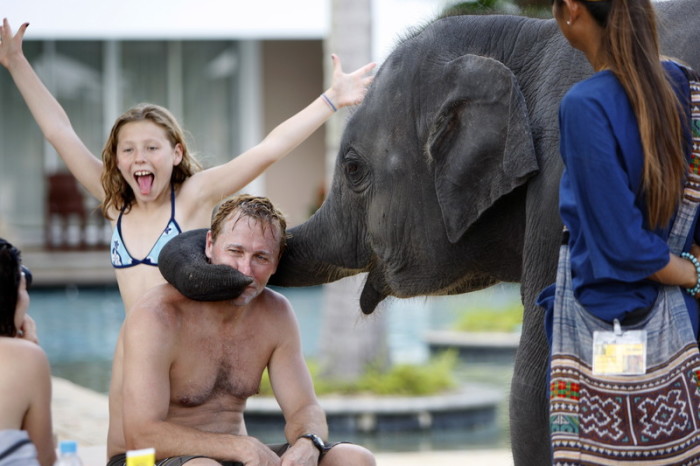 Eine russische Familie vergnügt sich bei einem Ausflug in ein thailändisches Elefantencamp. Foto: epa/Barbara Walton