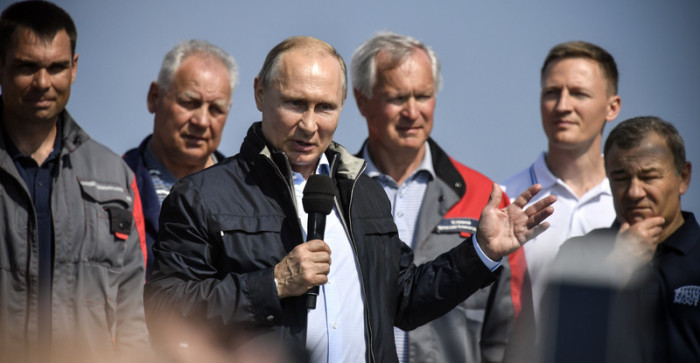 Der russische Präsident Wladimir Putin (M.) hält eine Rede zur Eröffnung der monumentalen Brücke. Foto: epa/Alexander Nemenov