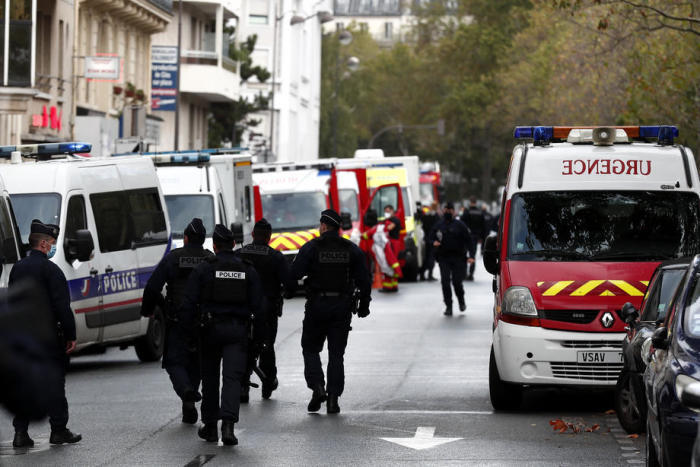 Französische Polizei- und Rettungsmannschaften stehen an einem Sicherheitsperimeter in der Nähe der ehemaligen Charlie-Hebdo-Büros in Paris. Foto: epa/Ian Langsdon