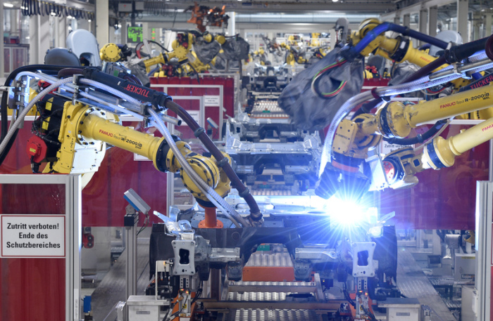 Schweißroboter arbeiten in der Karosseriefertigung vom VW Tiguan im Volkswagen Werk an der Bodengruppe des Modells. Foto: Rainer Jensen/Dpa