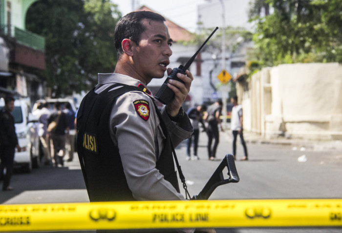 Ein indonesischer Polizeibeamter sichert das Gebiet nach einer Bombenexplosion in Surabayas Polizeipräsidium in Surabaya, Ost-Java, Ost-Java, Indonesien, 14. Mai 2018. Foto: epa/Fully Handoko