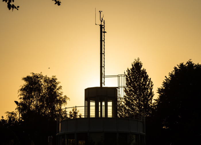 Die Sonne geht hinter der Wetterwarte des Deutschen Wetterdienstes (DWD) auf. Foto: Christophe Gateau/Dpa