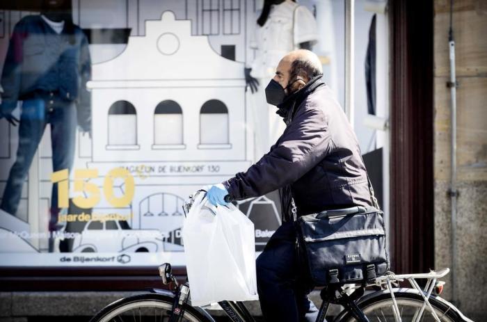Eine Radfahrerin trägt einen Gesichtsschutz in Amsterdam. Foto: epa/Koen Van Weel