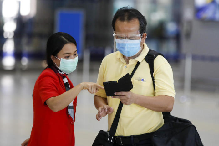 Ein thailändischer Geschäftsmann erhält Auskunft von einer Airline-Mitarbeiterin am Bangkoker Don Mueang Airport. Foto: epa/Diego Azubel