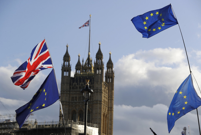 Die Flaggen von Großbritannien und der Europäischen Union wehen vor dem britischen Parlament. Das Parlament hat eine Entscheidung über den Brexit-Deal von Premierminister Johnson verschoben. Foto: Kirsty Wigglesworth/Ap/dpa