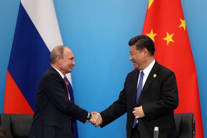 Der chinesische Präsident Xi Jinping (r.) schüttelt dem russischen Präsidenten Wladimir Putin die Hand (l.). Archivbild: epa/Wu Hong