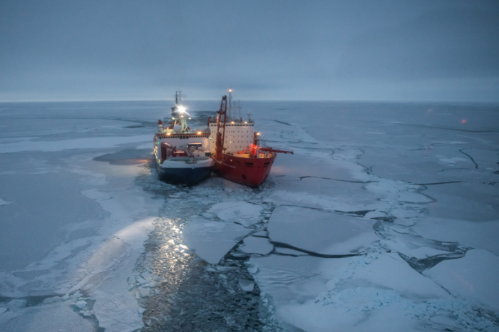 Der Forschungseisbrecher Polarstern (l) vom Bremerhavener Alfred-Wegener-Instituts (Awi) und der russische Eisbrecher Akademik Fedorov (r) liegen zwischen arktischen Eisschollen. Foto: Esther Horvath/Alfred-wegener-institut/dpa
