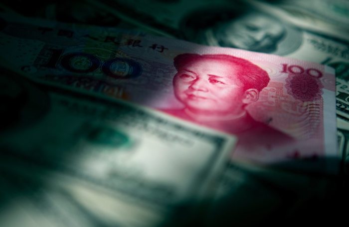 Ein Lichtstrahl fällt auf chinesische und US-amerikanische Banknoten. Foto: Diego Azubel/Epa/dpa