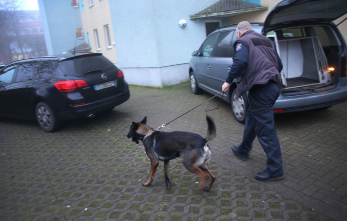 Ein Polizeihund wird zu einem Wohnhaus geführt. Bundesinnenminister Seehofer (CSU) hat die rechtsextreme Gruppe «Combat 18» verboten. Foto: René Werner/Dpa