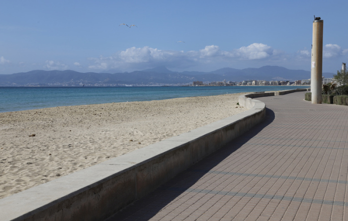 Der Strand S'Arenal und der Strandweg sind menschenleer. Corona wütet seit Wochen. Der in Spanien überlebenswichtigen Tourismusbranche wird aber erst jetzt das ganze Ausmaß des Dramas bewusst. Foto: Clara Margais/dpa
