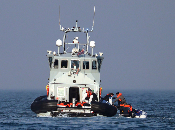 Grenzschutzbeamte helfen einer Gruppe mutmaßlicher Migranten an Bord der HMC Hunter, nachdem diese bei ihrer Fahrt in einem kleinen Boot über den Ärmelkanal in Richtung Dover aufgehalten wurden. Foto: Gareth Fuller/dpa