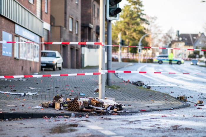 Absperrband der Polizei sperrt einen Teil der Osterfelder Straße ab. Auf dem Boden liegen verbrannte Feuerwerkskörper. Foto: Marcel Kusch/Dpa