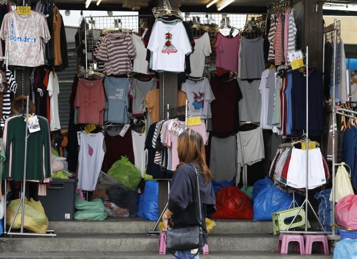 Eine Frau schaut auf die Auslagen eines Verkaufsstandes für Textilien in Bangkok. Laut der Thailändischen Zentralbank könnte die heimische Wirtschaft dieses Jahr um 8,1 Prozent schrumpfen. Foto: epa/Narong Sangnak