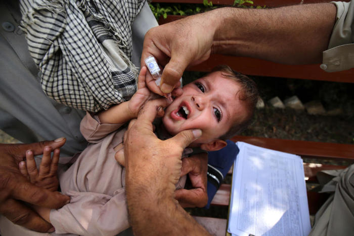 Ein Mitarbeiter des Gesundheitswesens verabreicht Kindern den Polio-Impfstoff während einer Polio-Impfkampagne von Tür zu Tür in Peshawar. Foto: epa/Arshad Arbab