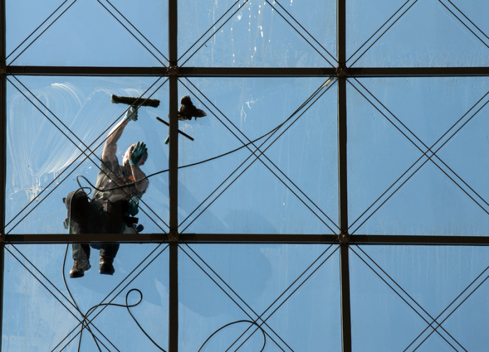 Ein spezialisierter Glas- und Gebäudereiniger putzt in 27 Metern Höhe das gläserne Dach des World Trade Centers (WTC). Foto: Robert Michael/Zb/dpa