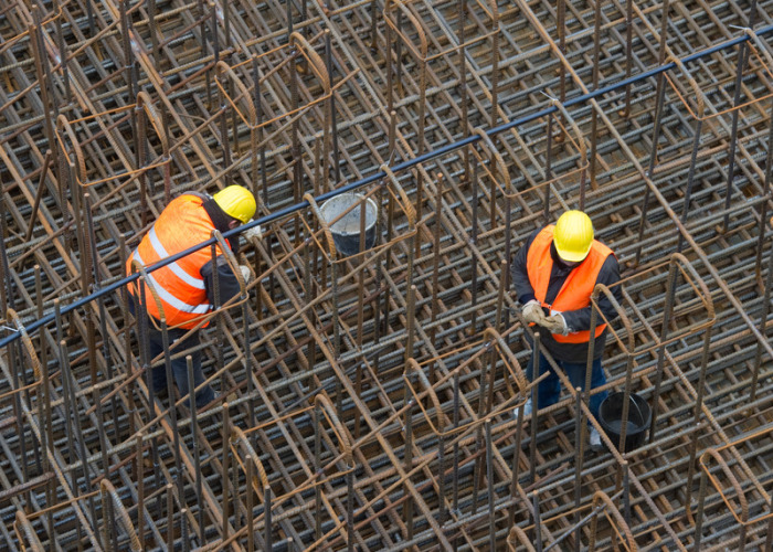 Bauarbeiter errichten auf einer Baustelle ein Stahlgeflecht. Foto: Patrick Pleul/Zb/dpa