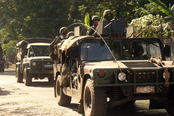 Mitglieder der philippinischen Marines an Bord von Militärlastwagen kehren nach ihrem Einsatz in der Stadt Patikol zu ihrem Lager zurück. Foto: epa/Ben Hajan
