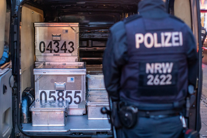 Polizeibeamte sichern kistenweise Beweise nach einer Durchsuchung in einem Geschäft. Foto: Christoph Reichwein/Dpa