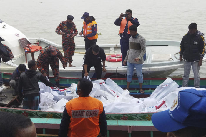 Feuerwehr und Küstenwache transportieren die Leichensäcke der Opfer, nachdem eine Passagierfähre in der Nähe der südlichen Landstadt Jhalakathi in Brand geraten war. Foto: epa/Str