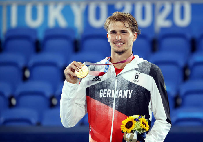Deutschlands Goldmedaillengewinner Alexandar Zverev jubelt auf dem Podium nach dem Gewinn der Goldmedaille im Herreneinzel. Foto: epa/Mast Irham