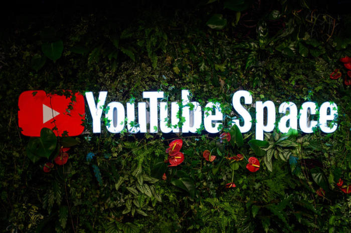 Das Logo des neuen YouTube Space im Stadtbezirk Mitte ist während der Eröffnungsveranstaltung an einer mit Pflanzen bewachsenen Wand zu sehen. Foto: Gregor Fischer/Dpa