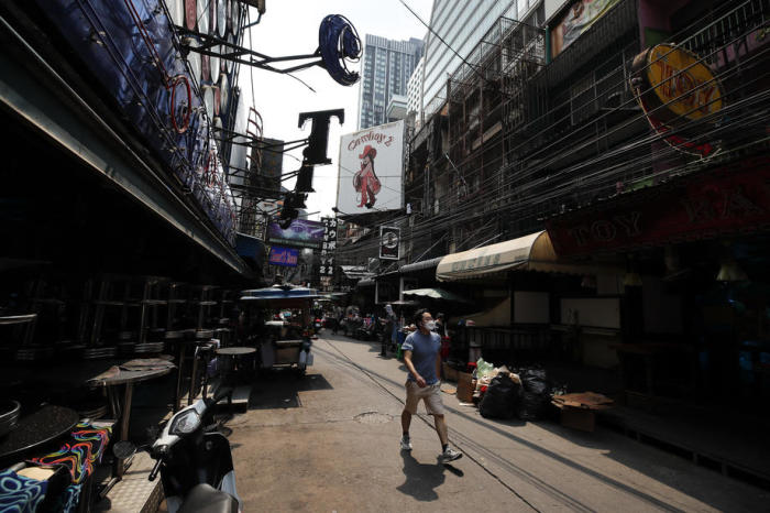 Ein Passant spaziert durch Bangkoks bekanntes Rotlichtviertel Soi Cowboy. Seit Monaten gleicht der Kiez einer Geisterstadt. Foto: epa/Diego Azubel