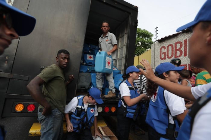 Rote-Kreuz-Mitarbeiter verteilen Hilfsgüter in Caracas, Venezuela. Foto: epa/efe/Rayner Pena
